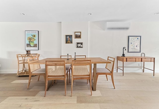 dining space with light wood-type flooring and an AC wall unit