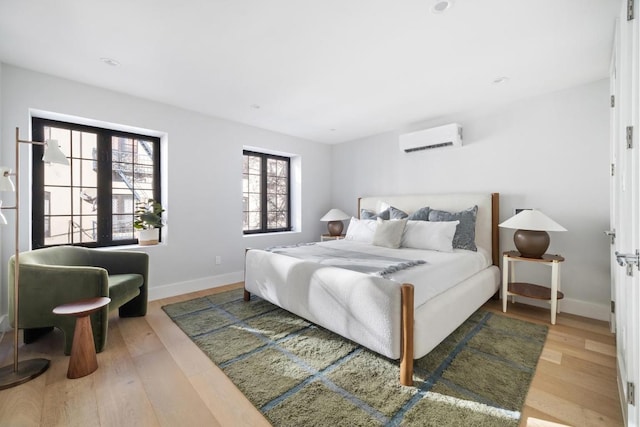 bedroom with a wall mounted AC and hardwood / wood-style floors