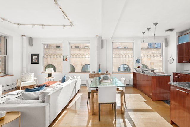 dining area with light wood-type flooring and a baseboard heating unit