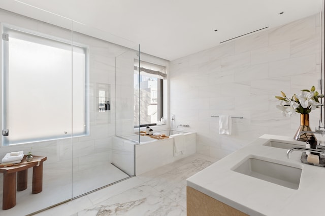 bathroom with tile walls, vanity, and separate shower and tub