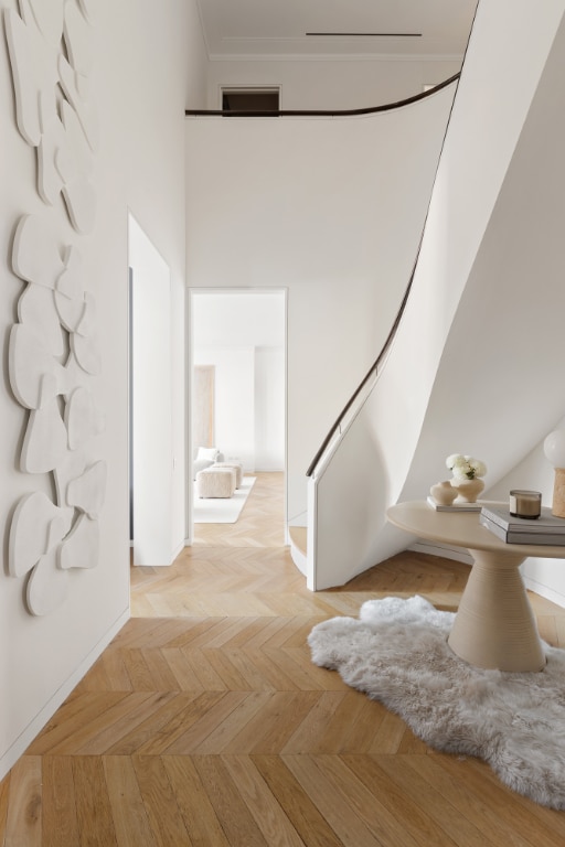 hallway with light parquet floors and a high ceiling