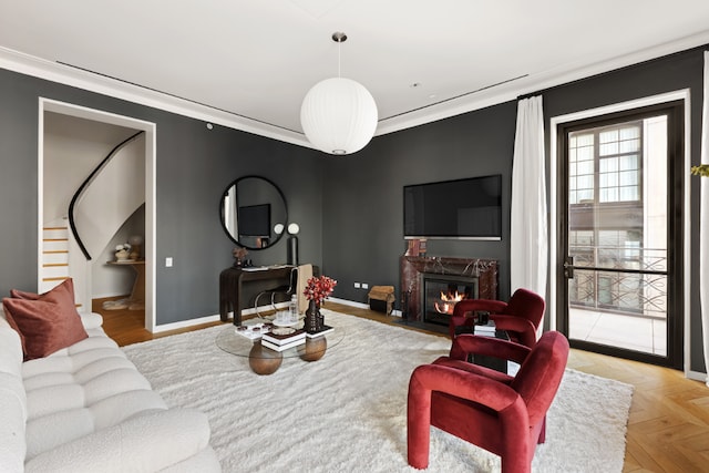 living room with a fireplace, crown molding, and light parquet floors