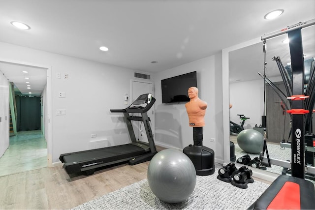 workout area with light hardwood / wood-style flooring