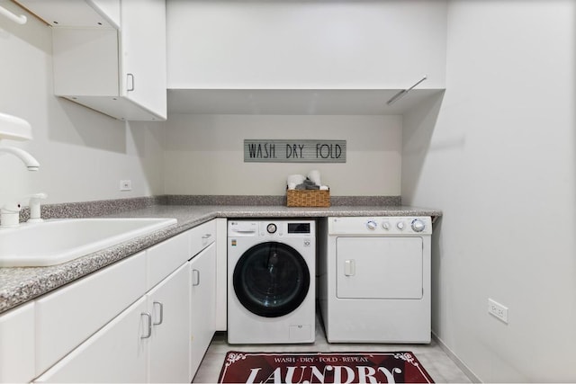 washroom featuring light tile patterned floors, sink, washer and dryer, and cabinets