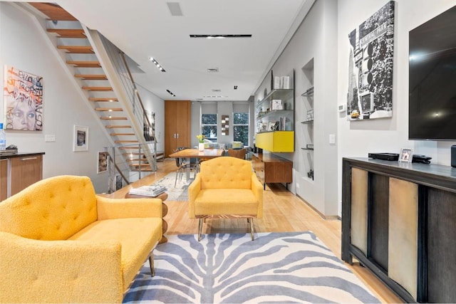 living room with light wood-type flooring and built in features