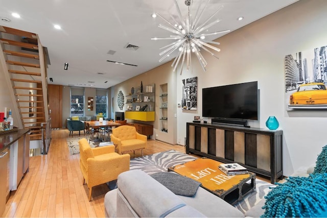 living room with light hardwood / wood-style flooring and an inviting chandelier