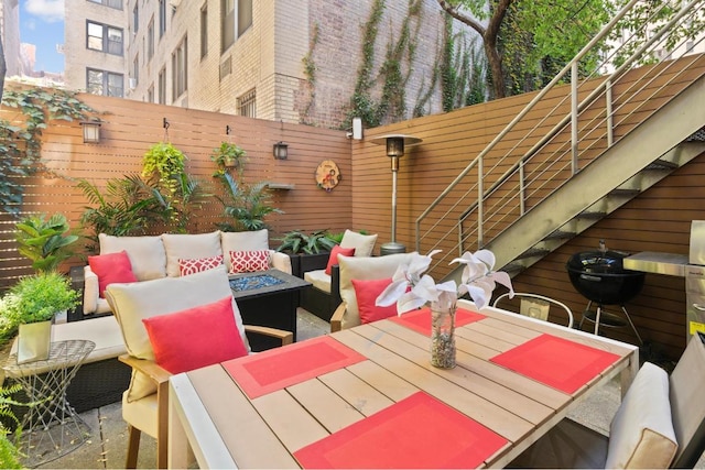 view of patio with an outdoor living space with a fire pit