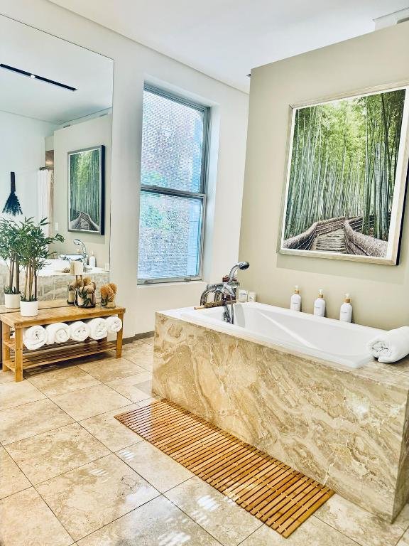 bathroom with tiled bath and tile patterned floors