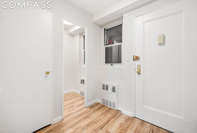 washroom with radiator and light hardwood / wood-style floors