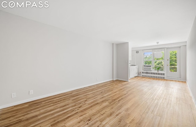 unfurnished living room with light wood-type flooring and radiator heating unit