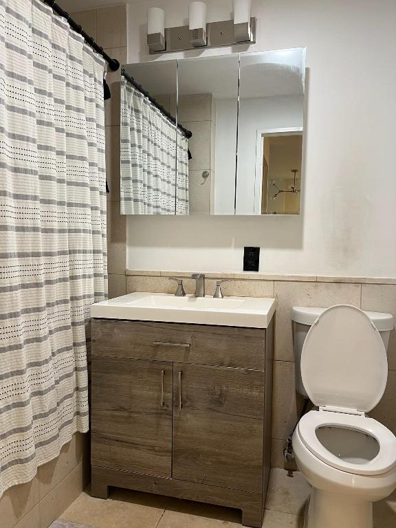 bathroom featuring curtained shower, tile walls, and vanity