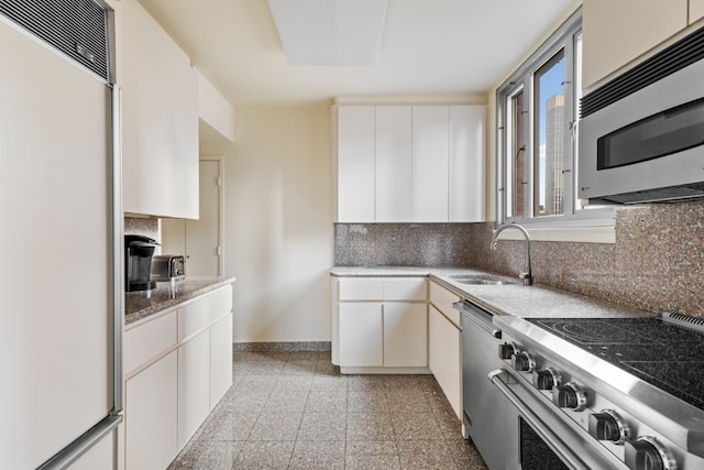 kitchen featuring stainless steel appliances, backsplash, white cabinets, and sink