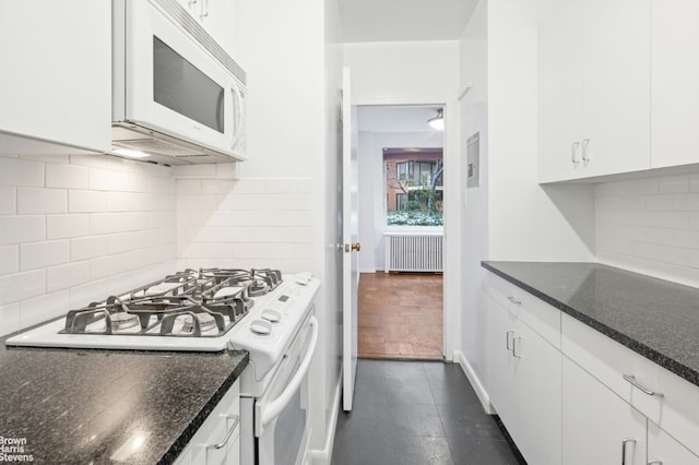 kitchen featuring decorative backsplash, white cabinets, radiator heating unit, and white appliances