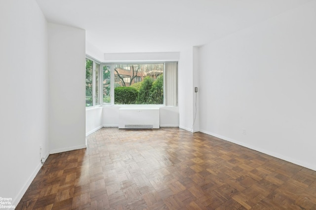 spare room featuring dark parquet floors