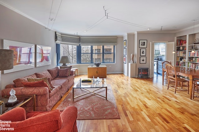 living room featuring a wood stove, light hardwood / wood-style flooring, and ornamental molding