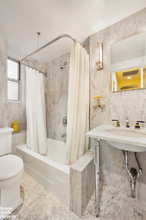 bathroom with shower / bath combo with shower curtain, tile walls, and toilet