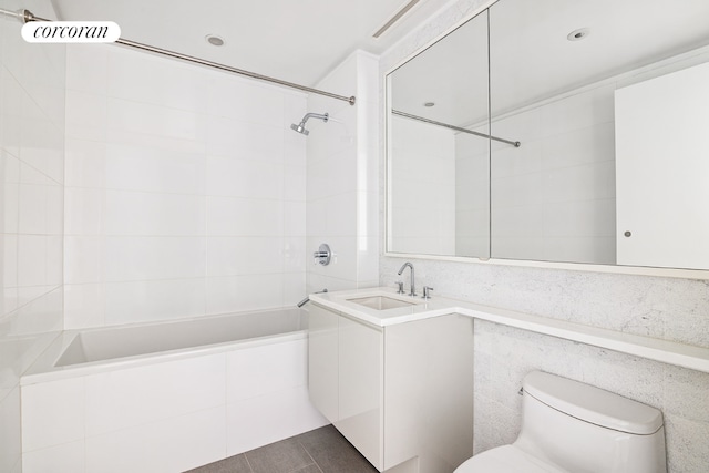 full bathroom featuring toilet, vanity, tile patterned floors, and tiled shower / bath