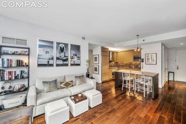 living room featuring dark wood-type flooring and ceiling fan