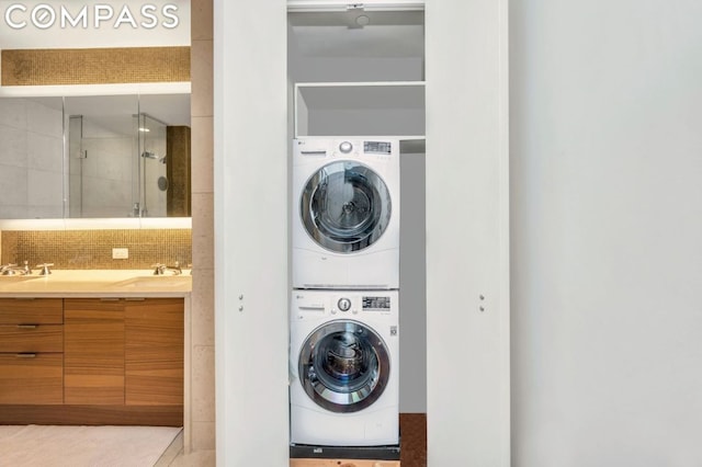 laundry room with sink and stacked washer / dryer