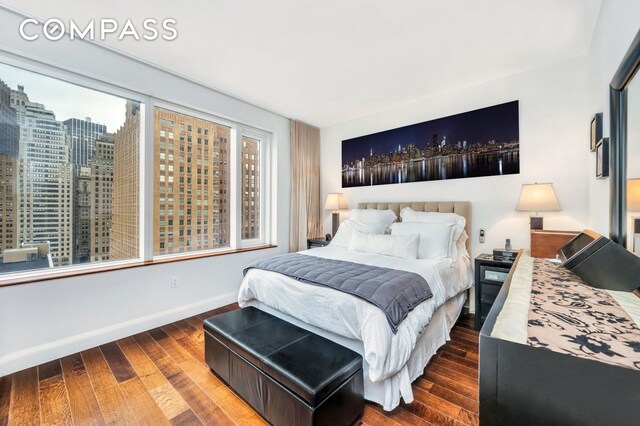 70 Little W St Unit 15A, New York City, NY 10004 - bedroom with wood-type flooring, baseboards, and a city view