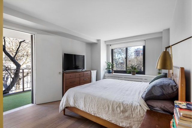 bedroom featuring access to exterior and light hardwood / wood-style flooring