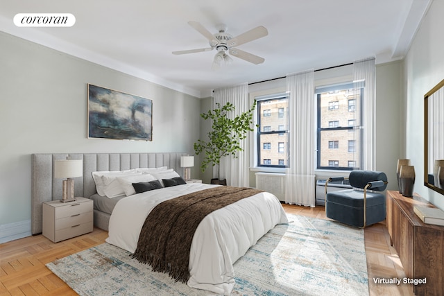 bedroom featuring light parquet flooring, radiator heating unit, and ceiling fan