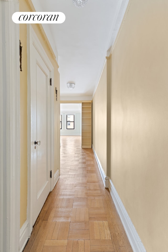 hall with ornamental molding and baseboards