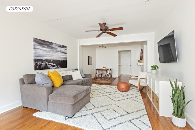 living room with ceiling fan and light hardwood / wood-style flooring