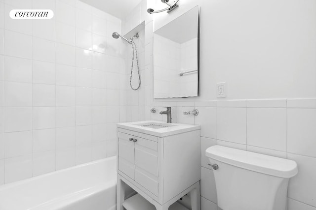 full bathroom featuring toilet, vanity, tile walls, and tiled shower / bath combo