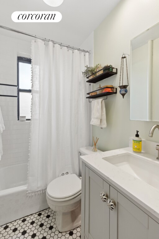 full bathroom with toilet, vanity, tile patterned flooring, and shower / bath combo with shower curtain