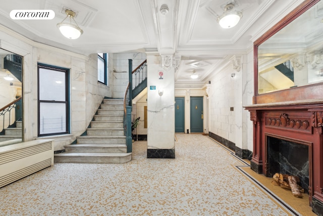 staircase with ornamental molding and decorative columns