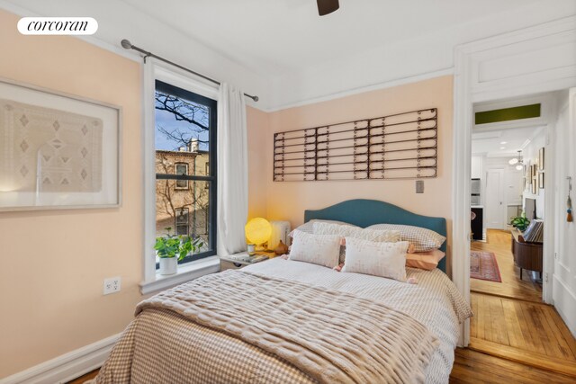 living area featuring a healthy amount of sunlight, wood-type flooring, an inviting chandelier, and ornamental molding