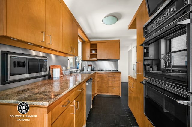 kitchen with light stone countertops, sink, and stainless steel appliances