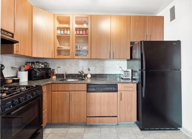 kitchen with sink, dark stone countertops, backsplash, and black appliances