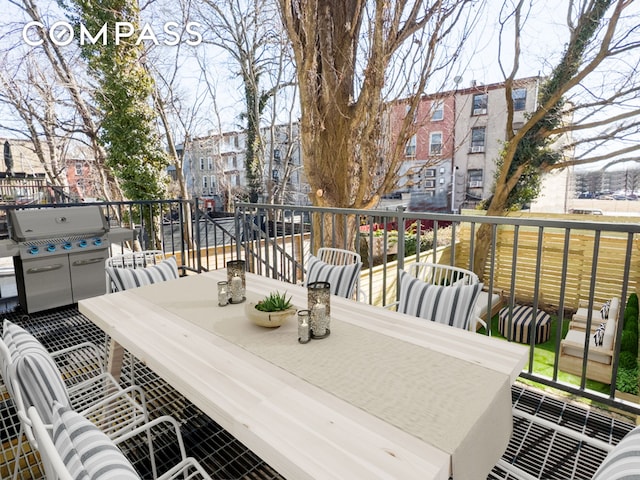 wooden terrace featuring a grill and outdoor dining area