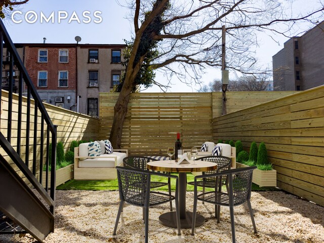 view of patio / terrace with stairs, outdoor dining area, and fence