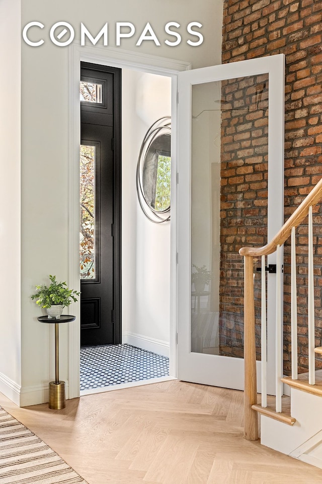 foyer featuring baseboards and stairs