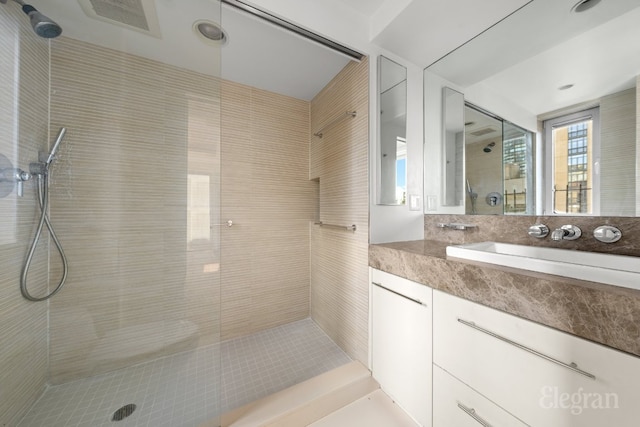 bathroom with vanity and tiled shower