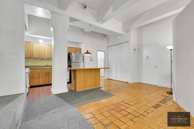 kitchen with tasteful backsplash, electric range, stainless steel refrigerator, a breakfast bar, and sink