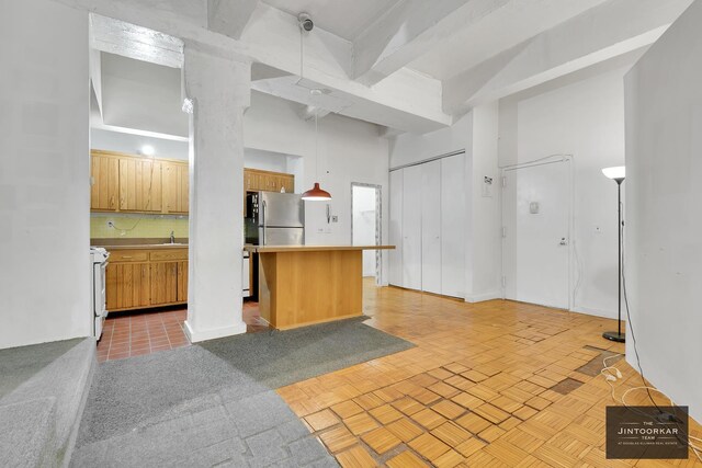 529 W 42nd St Unit 5M, New York City, NY 10036 - kitchen with tasteful backsplash, a kitchen bar, sink, stainless steel refrigerator, and white electric range oven