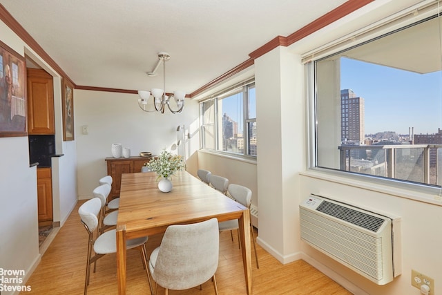 dining area with a wall unit AC, ornamental molding, an inviting chandelier, and light wood-type flooring