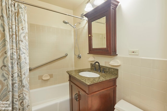 bathroom with vanity, tile walls, and shower / tub combo