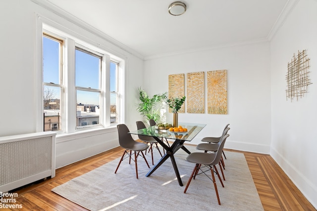 dining area featuring ornamental molding, hardwood / wood-style floors, radiator heating unit, and a wealth of natural light