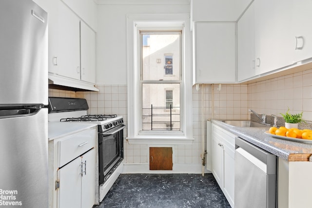 kitchen featuring a healthy amount of sunlight, appliances with stainless steel finishes, sink, and white cabinetry