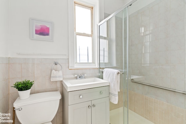 bathroom featuring toilet, a shower with door, and vanity