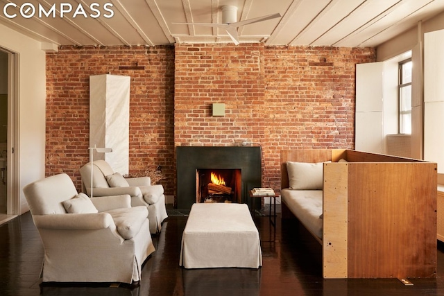 living area featuring brick wall