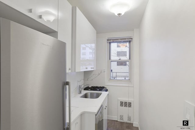 clothes washing area with radiator and sink