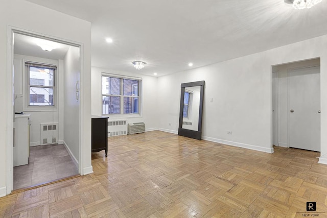 empty room featuring radiator heating unit and light parquet floors