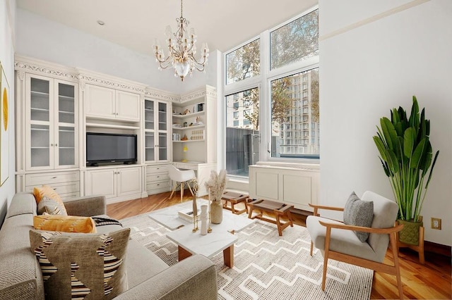 sitting room with light wood-style floors and an inviting chandelier