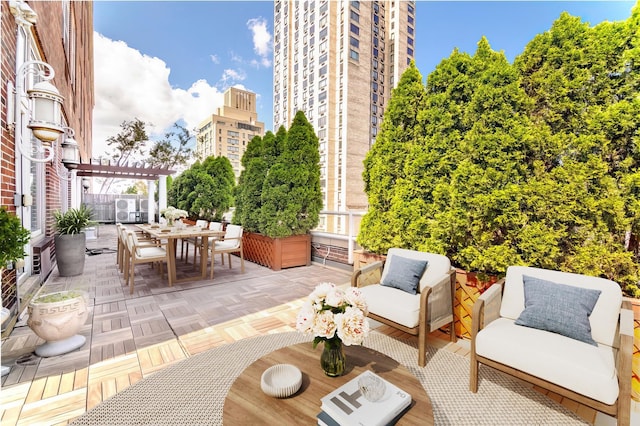 view of patio / terrace featuring a city view, outdoor dining space, and a pergola